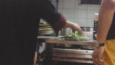 7月23日，漢麗軒烤肉超市昌平店，服務(wù)員將幾盤顧客剩菜（左手中疊在一起的是幾盤肉，其右手正整理韭菜）端回后廚，進(jìn)行整理后準(zhǔn)備再送往餐廳自助取餐區(qū)供顧客食用。